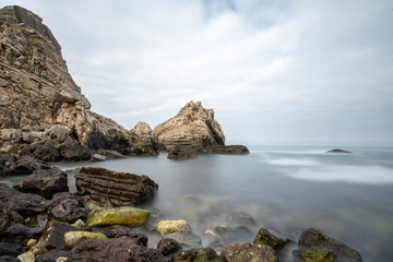 Fototapeta na wymiar Black sea and the beach with rocks and waves with cloudy sky, 