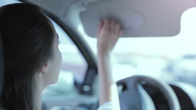 Back View Of Nice Stylish Woman Driver Touching A Rear View Mirror And Correcting The Hairstyle While Driving The Car