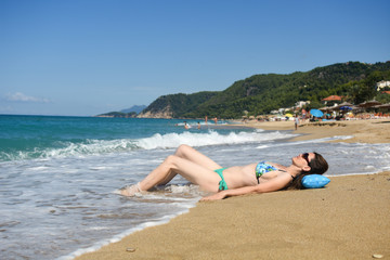Fototapeta na wymiar Woman lies and enjoy at beach. Summer vacations concept, sexy woman on tropical beach