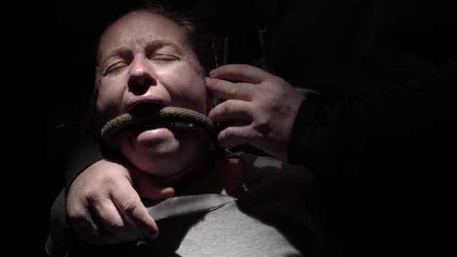 Kidnapper threatens girl with knife and calls on phone demanding money. Close-up.