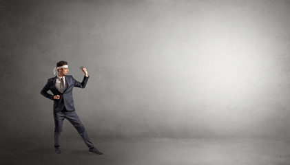 Small karate man fighting in an empty grey copy space