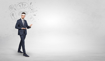 Fototapeta premium Young businessman in suit fighting with doodled symbols concept 
