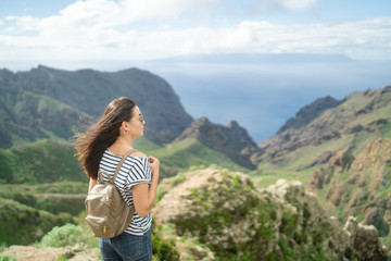 Pretty tourist brunette girl relaxing near mountains.