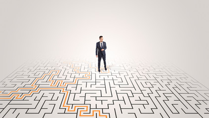 Young entrepreneur standing in a middle of a labyrinth with the solution

