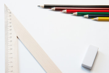 Colored pencils and wooden ruler on white background. Several different pencils.