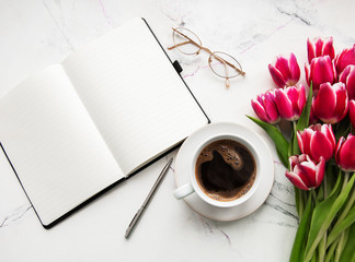 Notebook, cup of coffee  and pink tulips