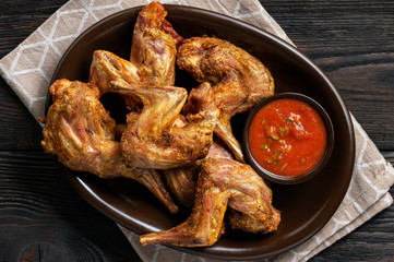 Grilled rabbit legs with spicy tomato dip.