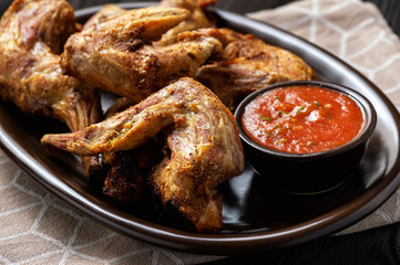 Grilled rabbit legs with spicy tomato dip.