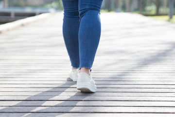 Girl walking along wooden footpath in park