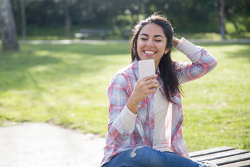 Happy delighted student girl using smartphone for video call