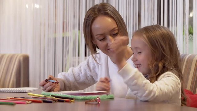 Positive Young Woman Is Drawing With Her Little Beautiful Daughter