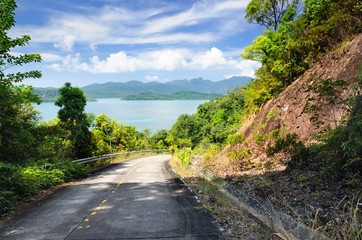 Fototapeta na wymiar Winding mountain road through rainforest at the coastline of the Koh Chand Island, Thailand.