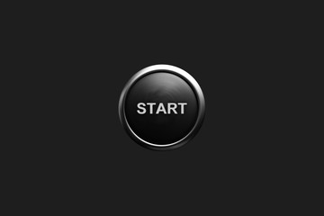 Black start button with silver metal ring edge, isolated on a dark gray background