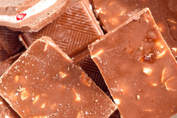 Milk chocolate pieces background from top view