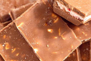 Milk chocolate pieces background from top view