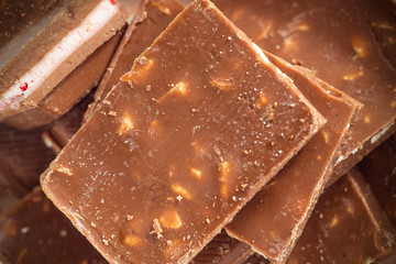 Milk chocolate pieces background from top view