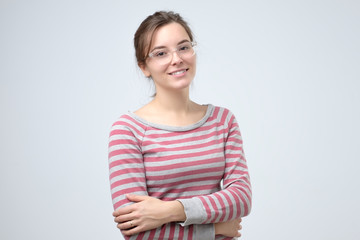Smiling young caucasian woman with her arms folded