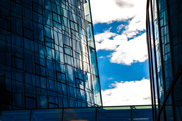Modern architecture of office buildings. A skyscraper from glass and metal. Reflections in windows of blue sky. Business center