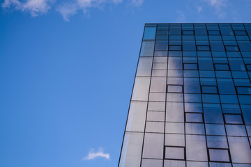 Modern architecture of office buildings. A skyscraper from glass and metal. Reflections in windows of blue sky. Business center