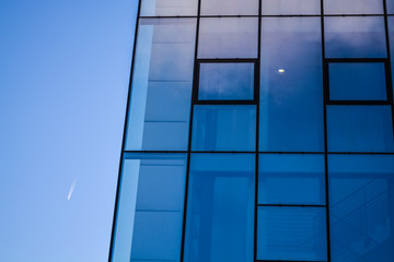 Modern architecture of office buildings. A skyscraper from glass and metal. Reflections in windows of blue sky. Business center