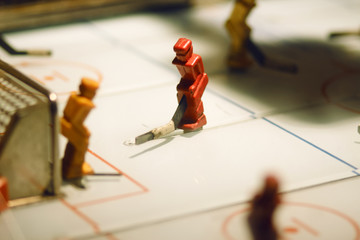 Table game with figures of hockey players: goalkeeper and striker in an old vintage slot machine
