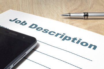 Fototapeta premium Job Description with smartphone and Pen on the table.