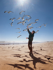 Landscape with sea, teenager and flying seagulls. Texas Coast, Gulf of Mexico, USA