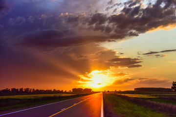 Landscape with road and stormy sky at sunset