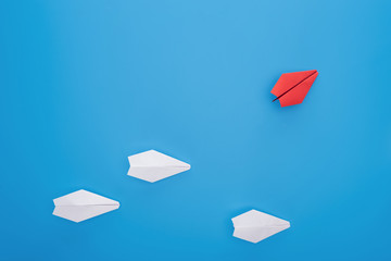 Flat lay with white and red paper planes on blue