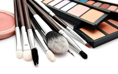 Various set of professional makeup brushes and palette of colourful eye shadows isolated