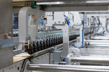 Man Inserting Carton into the Cart Paper Folding Machine Transfer Wheels Rollers Print Production