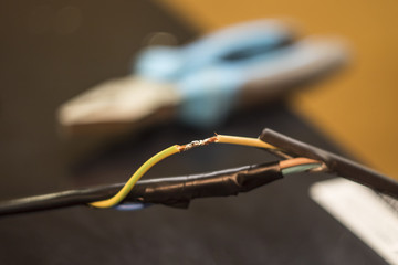electrical wire connection, soldering with a soldering iron, pliers against the background