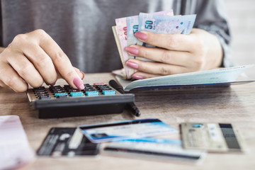 woman hand calculating monthly expenses for credit card debt with banknotes,   saving account 