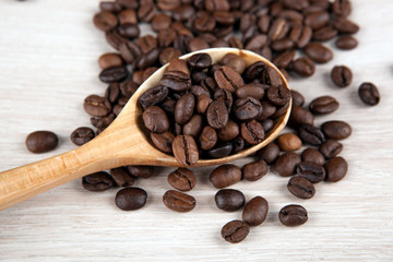 wooden spoon and roasted coffee beans close up