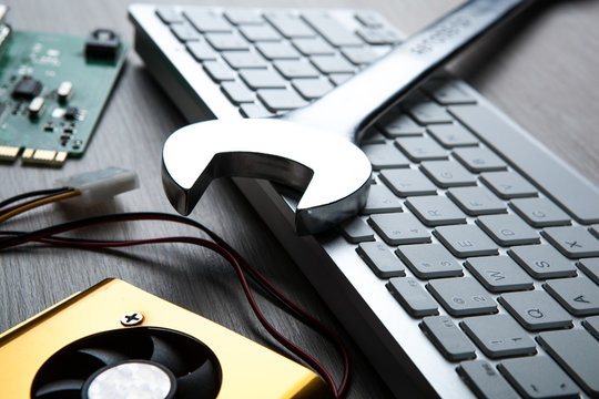 big wrench and a computer keyboard and computer parts