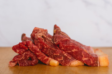 fresh raw beef meat steak slices on wooden cut board over white background