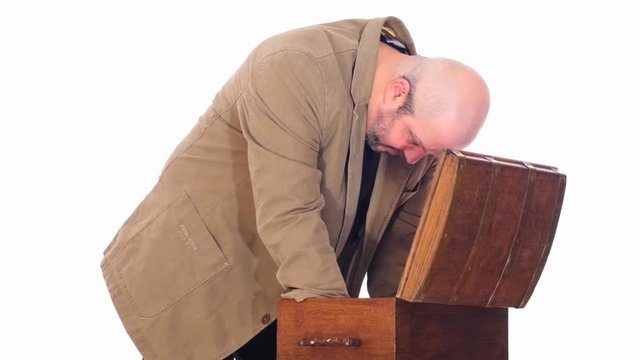 modern man opening antique chest follow focus white screen