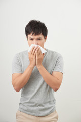 man is sick and sneezing with white background, asian