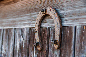 Old vintage horseshoe bolted to an old wooden door isolated