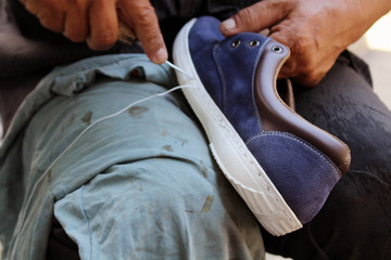 Process of manual shoe reparation, sole and welt fixing and stitching