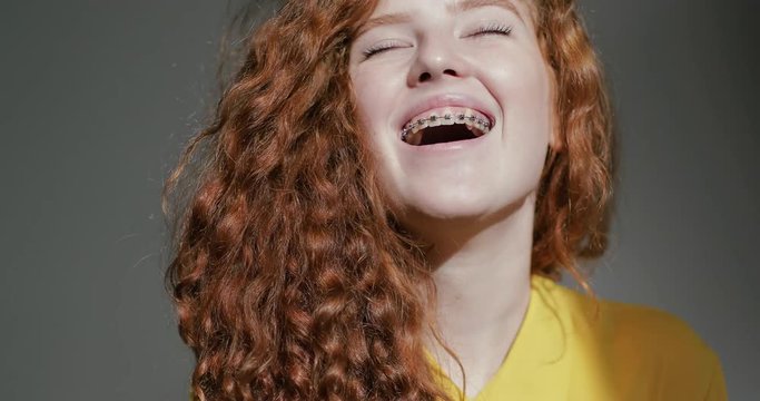 Portrait of a young girl with braces laughing at the camera