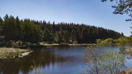 cod beck reservoir in north yorksire showing the blue waters and trees around the lake