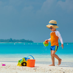 Three year old toddler playing on beach