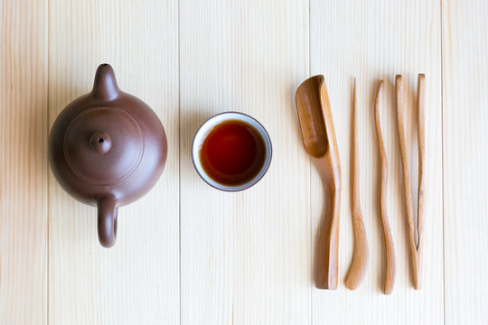 A set accessories for the tea ceremony. Dishes for tea and wooden sticks on a light background.