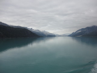 Pacific Ocean fading off to the Horizon between rolling mountains with a cloudy sky