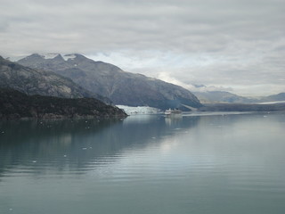 Glacier in the midst of gray mountains with little vegetation in Alaska