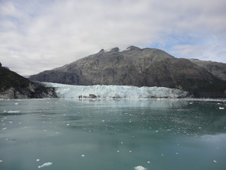 Fototapeta na wymiar Glacier in the midst of gray mountains with little vegetation in Alaska
