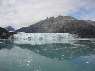 Glacier in the midst of gray mountains with little vegetation in Alaska