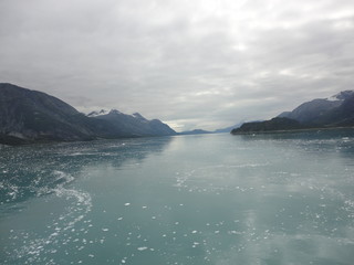 Fototapeta premium Passage in the Pacific Ocean between two mountain ranges. Calm peaceful waters flowing slowly under a cloudy sky.
