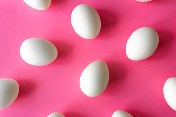 white eggs on a bright pink color background. Easter concept